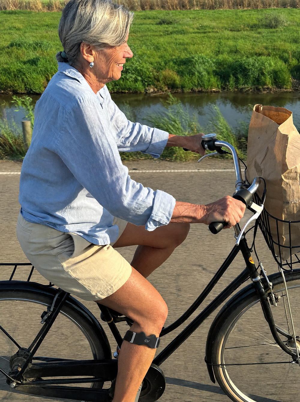 Vrouw fietst met boodschappen door de polder, met de Corevion Move onder de knie